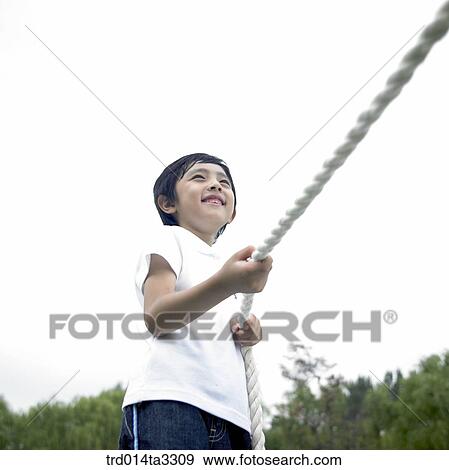 Boys playing at tug of war at the park View Large Photo Image Stock Photo - Boys playing at tug of war at the park. Fotosearch
