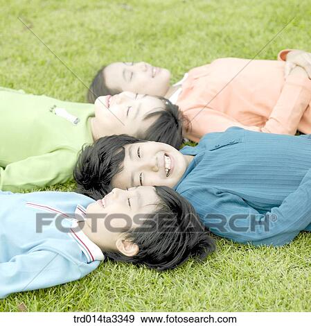 Stock Photo - Children lying down in the lawn. Fotosearch