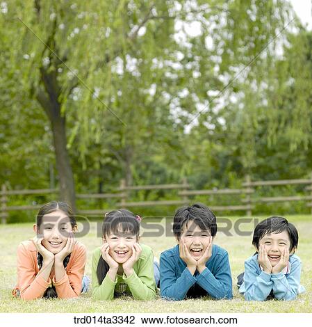 Children lying dwon in a row at the lawn View Large Photo Image Stock Image - Children lying dwon in a row at the lawn. Fotosearch