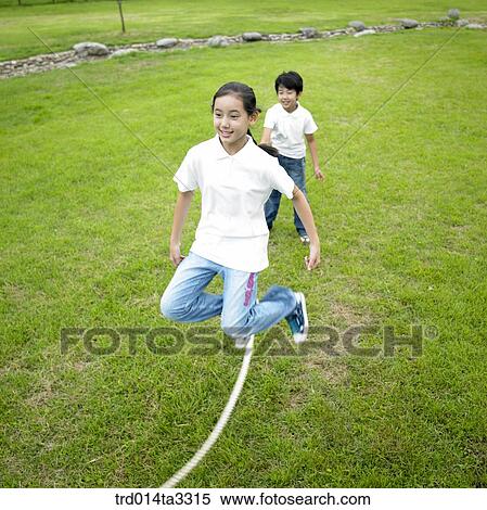 Stock Photography - Childrens jumping ropes at the park. Fotosearch