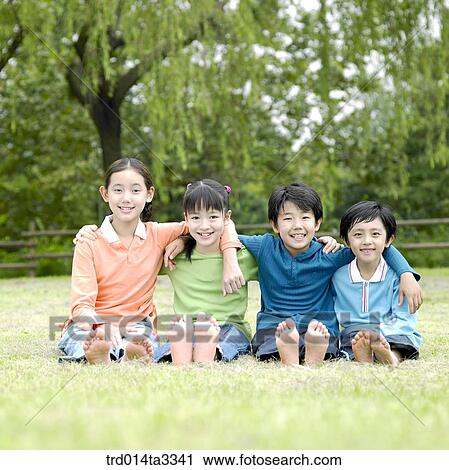 Stock Image - Childrens with their arms arounf their frineds' shoulder at the lawn. Fotosearch