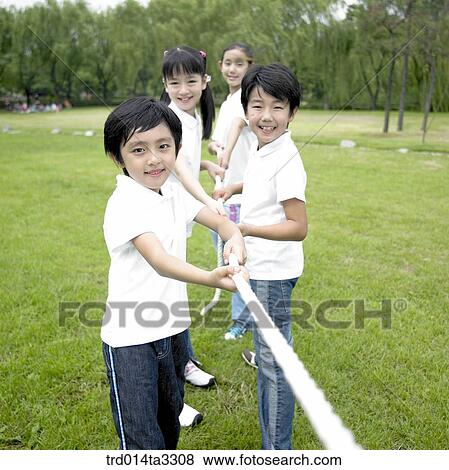 Stock Photo - Chlidren palying at tug of war at the park. Fotosearch