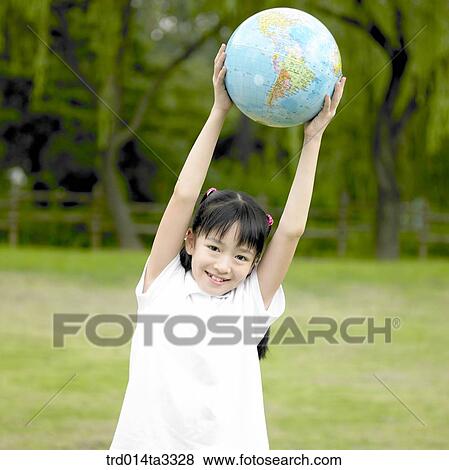 Stock Photo - girl holding up the globe in the park. Fotosearch