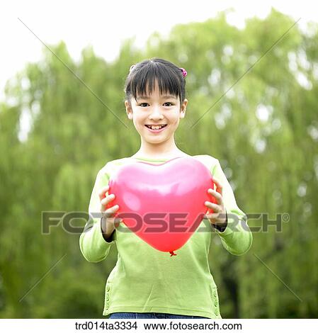 girl holdingheart shaped balloon View Large Photo Image Picture - girl holdingheart shaped balloon. Fotosearch
