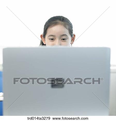 Girl looking at notebook computer View Large Photo Image Stock Photo - Girl looking at notebook computer. Fotosearch