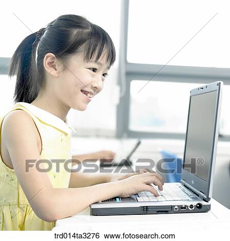 Girl looking at notebook computer View Large Photo Image Stock Photograph - Girl looking at notebook computer. Fotosearch