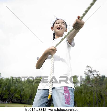 Girls playing at tug of war at the park View Large Photo Image Stock Image - Girls playing at tug of war at the park. Fotosearch