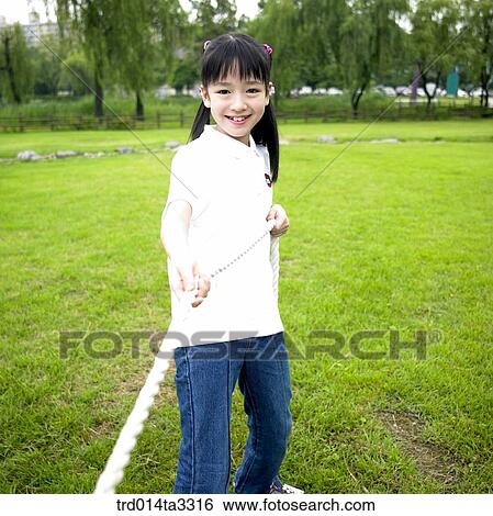 Girls playing at tug of war at the park View Large Photo Image Stock Photograph - Girls playing at tug of war at the park. Fotosearch