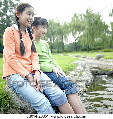 Girls puttign their feets in the stream View Large Photo Image Stock Image - Girls puttign their feets in the stream. Fotosearch