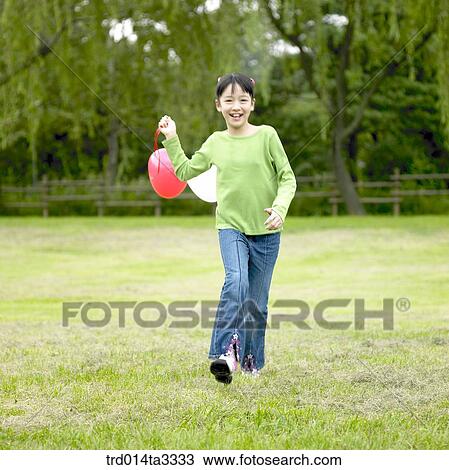 Stock Image - running girl holding balloon. Fotosearch