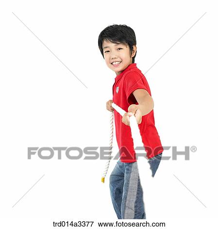 Boy playing at tug of war View Large Photo Image Stock Photo - Boy playing at tug of war. Fotosearch