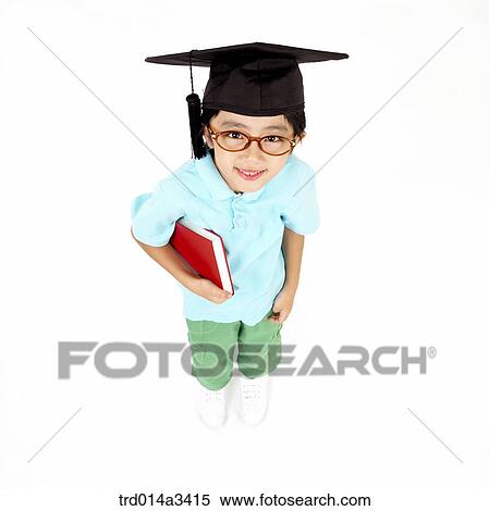 Stock Photography - boy wearing graduation cap with holding books. Fotosearch