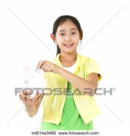 Stock Photograph - Girl putting coin in the saving box. Fotosearch