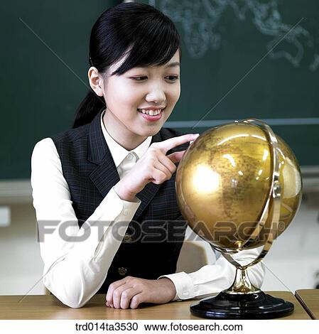 sitting student in uniform touchingthe globe in the classroom View Large Photo Image Stock Image - sitting student in uniform touchingthe globe in the classroom. Fotosearch