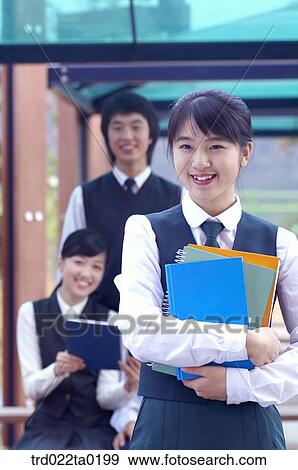 Student holding books in school View Large Photo Image Stock Photo - Student holding books in school. Fotosearch