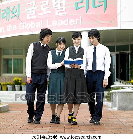 Student in uniform reading books while walking in school View Large Photo Image Stock Photograph - Student in uniform reading books while walking in school. Fotosearch