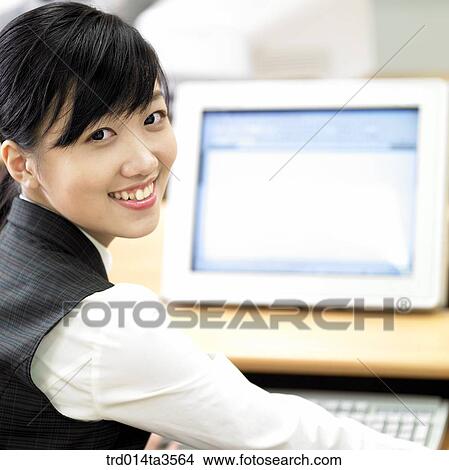 Picture - student in uniform taking computer class in school. Fotosearch