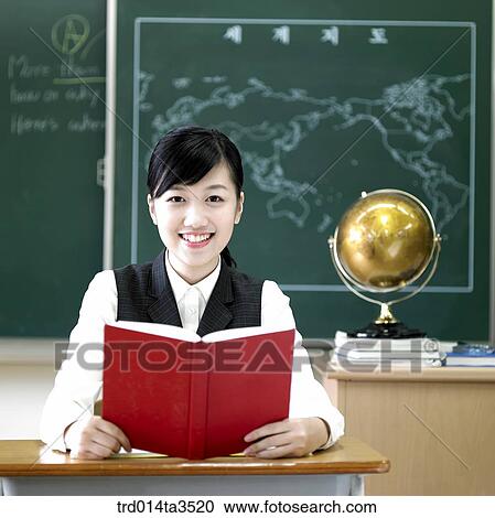 Studnets holding books at her desk View Large Photo Image Stock Image - Studnets holding books at her desk. Fotosearch