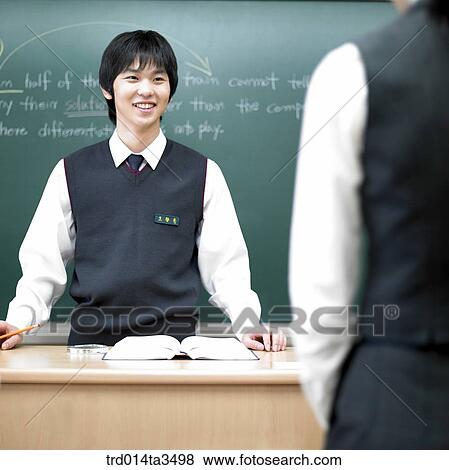 Studnets in uniform pointing his friend in English class in the classroom View Large Photo Image Stock Photo - Studnets in uniform pointing his friend in English class in the classroom. Fotosearch