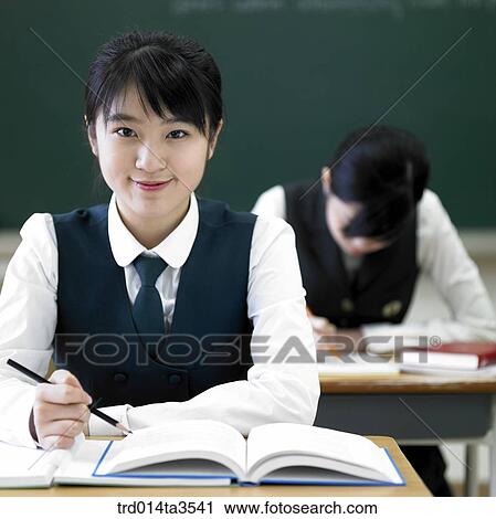 Stock Image - Studying student in uniform in the classroom. Fotosearch
