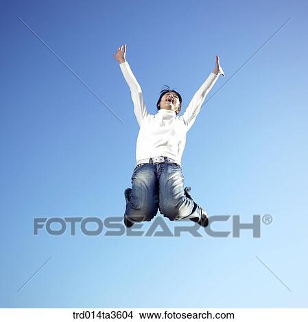 Picture - Girl cheering and jumping up. Fotosearch