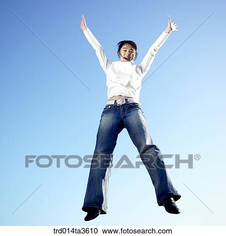 Girl jumping up with two hands up View Large Photo Image Stock Image - Girl jumping up with two hands up. Fotosearch
