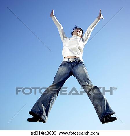 Girl jumping up with two hands up View Large Photo Image Stock Photo - Girl jumping up with two hands up. Fotosearch