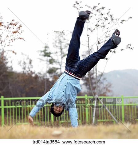 Picture - student doing hand-standing. Fotosearch