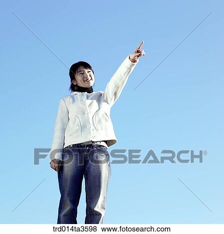 Student in wihte jumper ponitng at sky View Large Photo Image Stock Photo - Student in wihte jumper ponitng at sky. Fotosearch