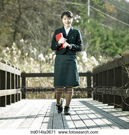 Teen girl holding books whiel walking the bridge View Large Photo Image Stock Image - Teen girl holding books whiel walking the bridge. Fotosearch