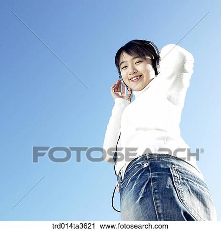 Teen girl listening music with hear headset View Large Photo Image Stock Image - Teen girl listening music with hear headset. Fotosearch