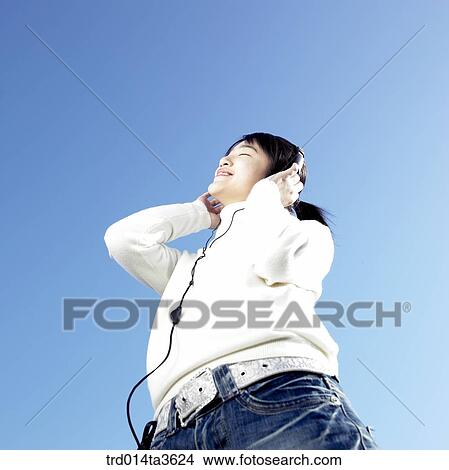 Picture - Teen girl listening music with her headset. Fotosearch