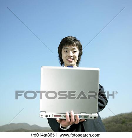 Teen holing notebook computer outside View Large Photo Image Stock Image - Teen holing notebook computer outside. Fotosearch