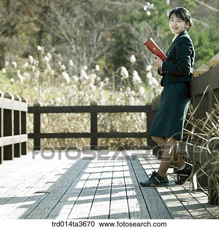 Teen leanning against fence andreading book at outside View Large Photo Image Stock Image - Teen leanning against fence andreading book at outside. Fotosearch