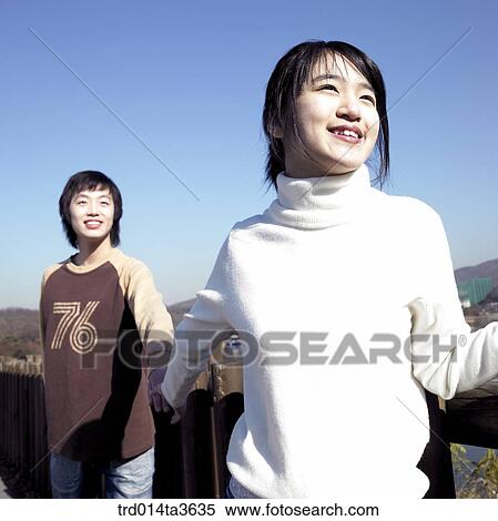Teens holding hands near the fence View Large Photo Image Stock Photography - Teens holding hands near the fence. Fotosearch