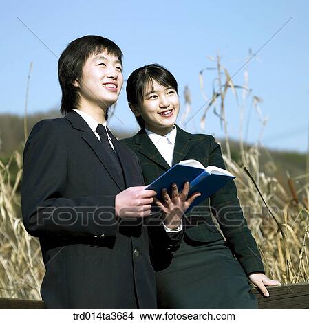 Teens in uniform looking at with holding books View Large Photo Image Picture - Teens in uniform looking at with holding books. Fotosearch