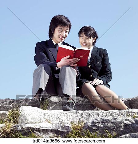 Teens in uniform reading books together View Large Photo Image Stock Photograph - Teens in uniform reading books together . Fotosearch