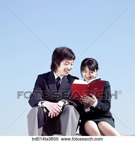 Teens in uniform reading books together View Large Photo Image Stock Photography - Teens in uniform reading books together . Fotosearch