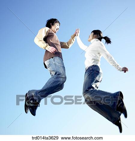 Teens jumping and doing high five View Large Photo Image Stock Photo - Teens jumping and doing high five. Fotosearch