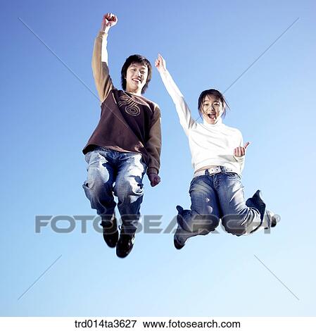 Stock Photo - Teens jumping with sheering. Fotosearch