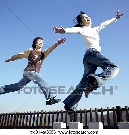 Stock Photograph - Teens running and jumping at the park. Fotosearch