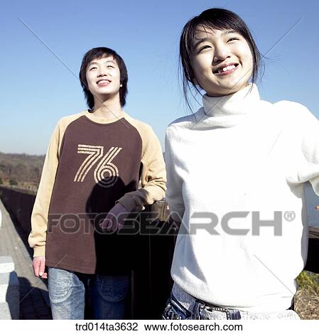 Stock Image - Teens standing near the lake. Fotosearch