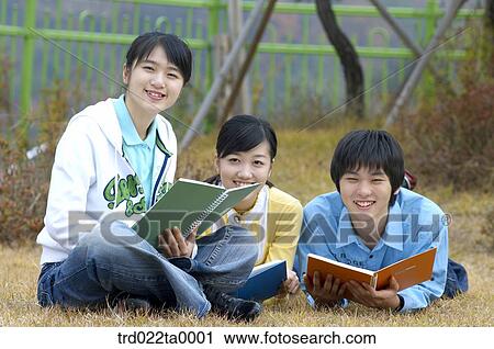 Teens studying together on the lawn View Large Photo Image Stock Image - Teens studying together on the lawn. Fotosearch