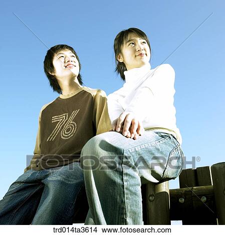 Teens with smile sitting on the fence View Large Photo Image Picture - Teens with smile sitting on the fence. Fotosearch