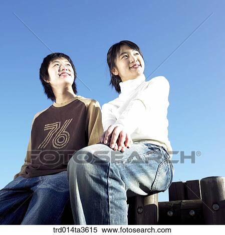 Teens with smile sitting on the fence View Large Photo Image Stock Photography - Teens with smile sitting on the fence. Fotosearch