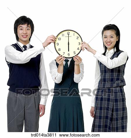 Teen girl holind clock on her face and her friends View Large Photo Image Stock Image - Teen girl holind clock on her face and her friends. Fotosearch
