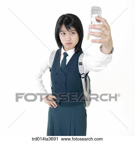 Teen girl in uniform taking picture with her cell phone camera View Large Photo Image Stock Image - Teen girl in uniform taking picture with her cell phone camera. Fotosearch