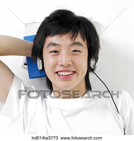Stock Image - Teen llaying down with listening music. Fotosearch