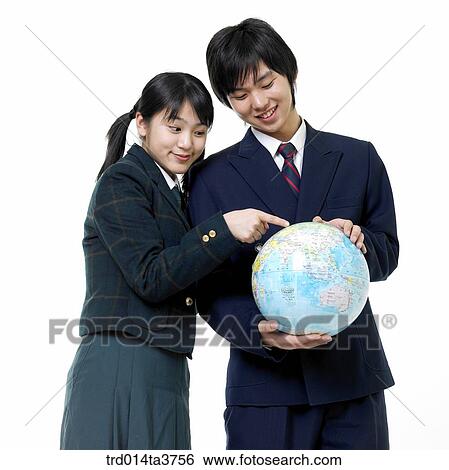 Teens in uniform pointing at globe View Large Photo Image Stock Photograph - Teens in uniform pointing at globe. Fotosearch