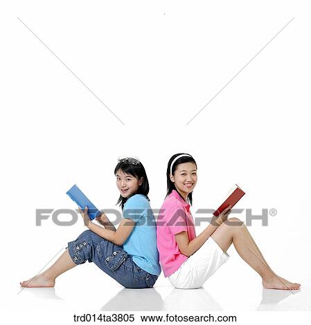 Teens reading books while leanning each other View Large Photo Image Stock Photography - Teens reading books while leanning each other. Fotosearch